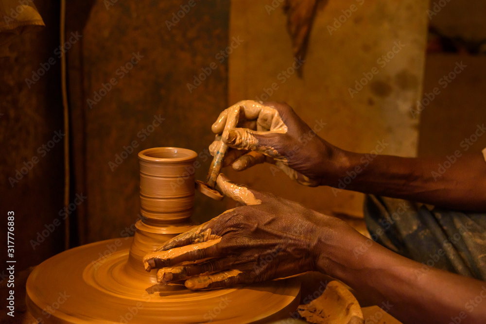 Indian potter making clay pots on pottery wheel in Pottery town is old place. Bangalore. India
