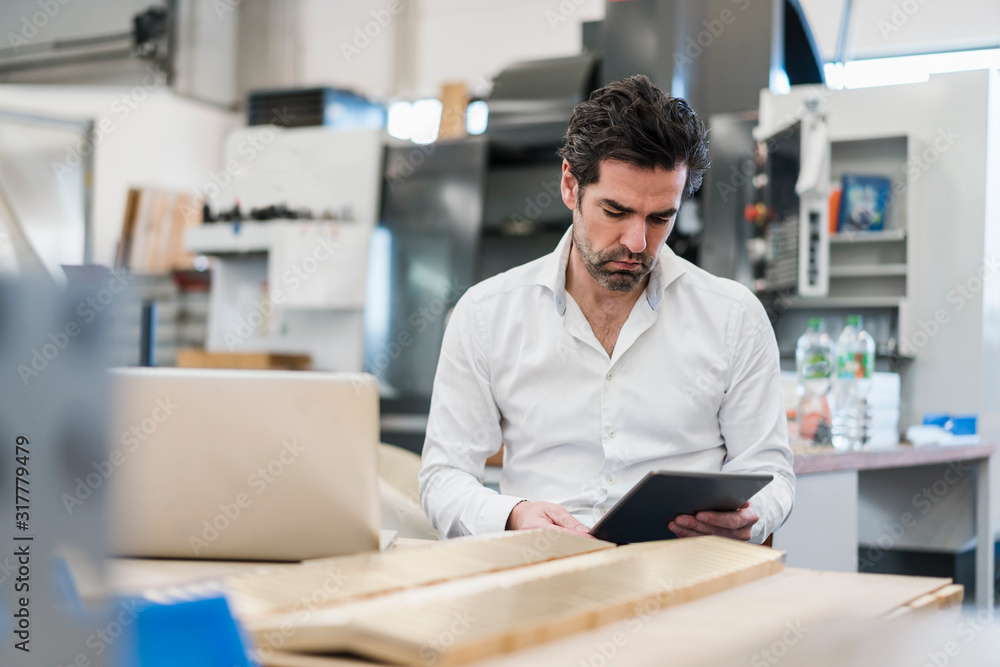 Businessman using tablet in a factory Businessman using tablet in a factory