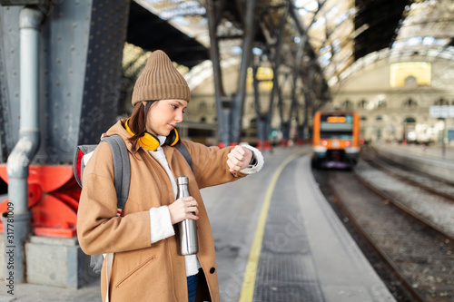 Young woman checking the time at the train station