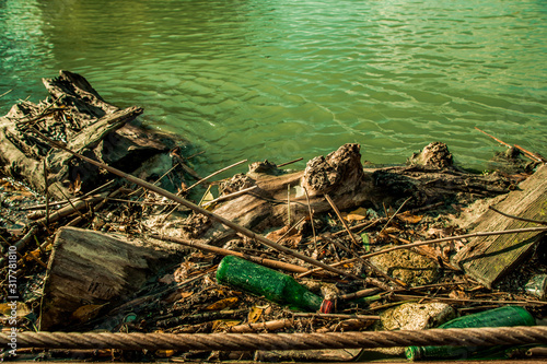 dirty green river with old garbage botle
