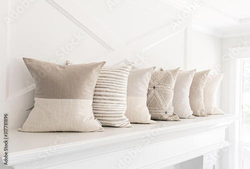 Neutral pillows on a fireplace mantle photo