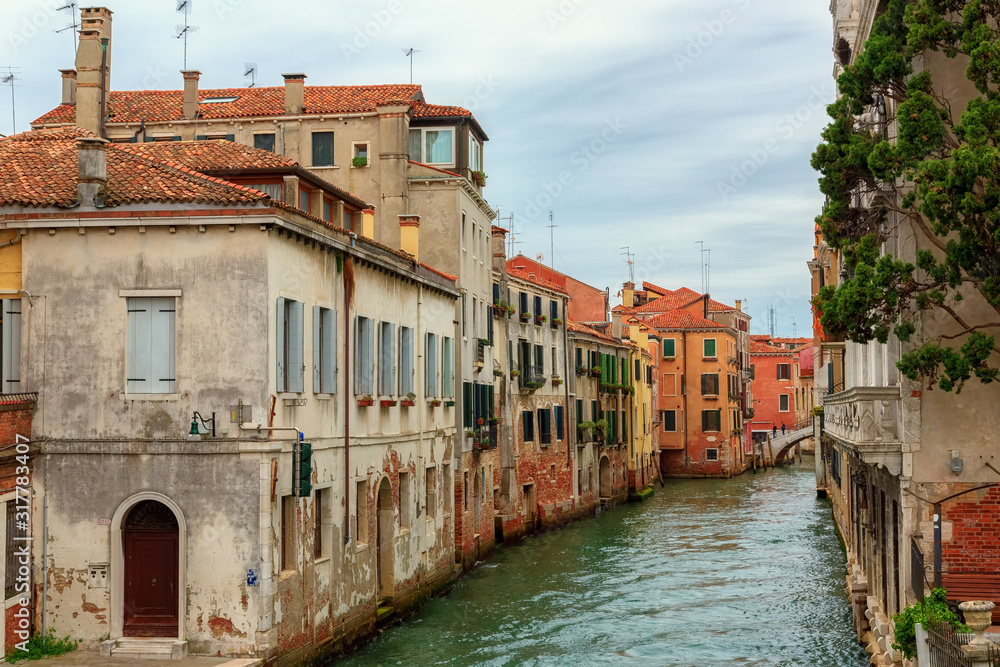 A beautiful photo of the canals of Venice through which gondolas walk and carry tourists