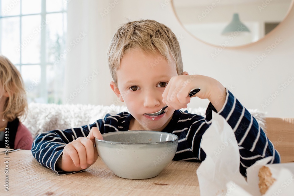young boy eating breakfast at home before school young boy eating breakfast at home before school