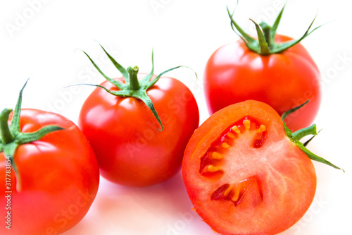 Three delicious ripe red tomatoes and a slice on white background. Side view. Healthy and organic food concept. Agriculture and harvesting. Vegetable store in supermarket. Illustration for price tag.