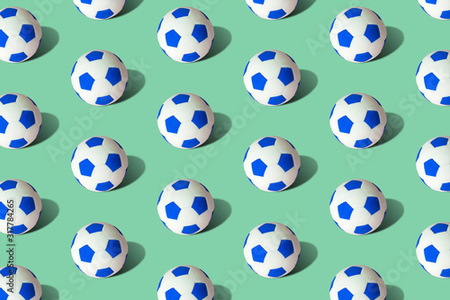 Soccer balls pattern on green background minimal creative sport concept. © zphoto83