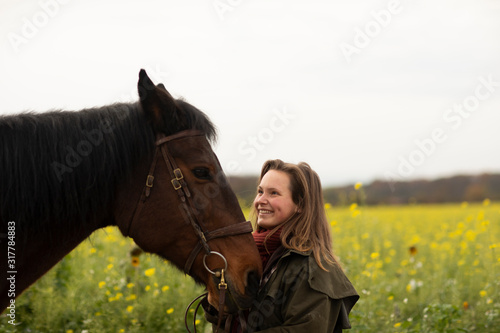 young horsewoman with a horse outeside photo