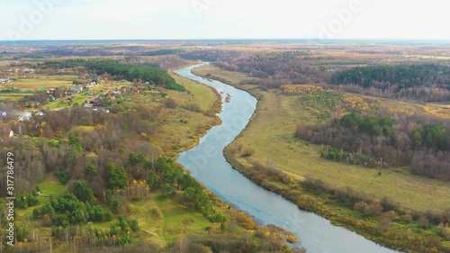 Flying Above River Along Colorful Autumn Forest On RiverBanks. Aerial View. Ugra River, Nikola Lenivets Park,  Kaluga Area, Russia photo