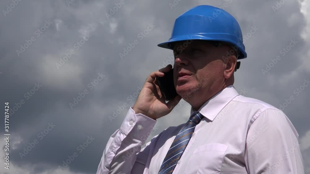 Exterior Shooting with a Businessman Wearing a Helmet and Talking to Mobile Exterior Shooting with a Businessman Wearing a Helmet and Talking to Mobile
