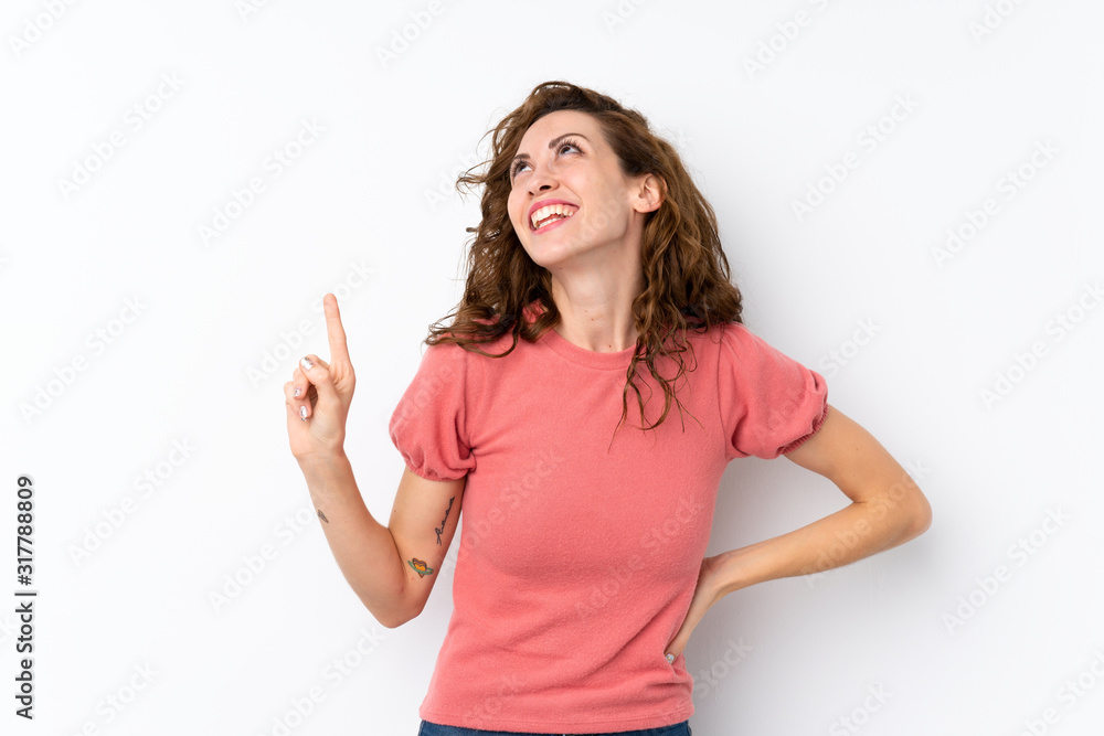 Young pretty woman over isolated background pointing up and surprised Young pretty woman over isolated background pointing up and surprised