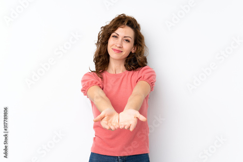 Young pretty woman over isolated background holding copyspace imaginary on the palm to insert an ad