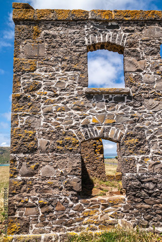 Stanley, Tasmania, Australia - December 15, 2009: Hightfield Historic Site. Looking through gray stone building ruins against blue cloudscape. photo