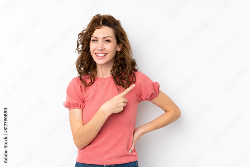 Young pretty woman over isolated background pointing to the side to present a product Young pretty woman over isolated background pointing to the side to present a product