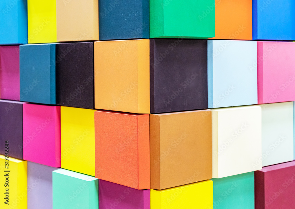 Multi-colored wooden cubes with 3D effect. Background from colored squares.