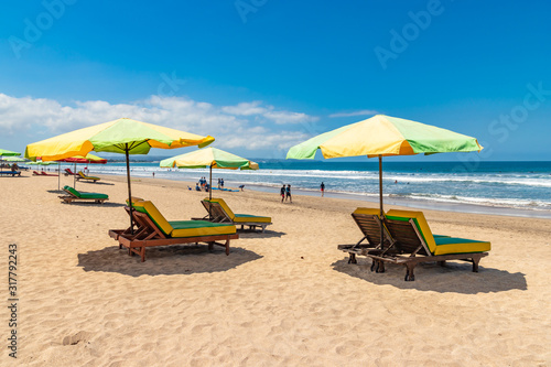 KUTA, BALI / INDONESIA - NOVEMBER 8, 2019: Kuta beach in Bali. Wide sandy beach with many sunbeds and umbrellas. Best place for surfing. photo