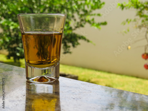 glass of cachaça with green plants background