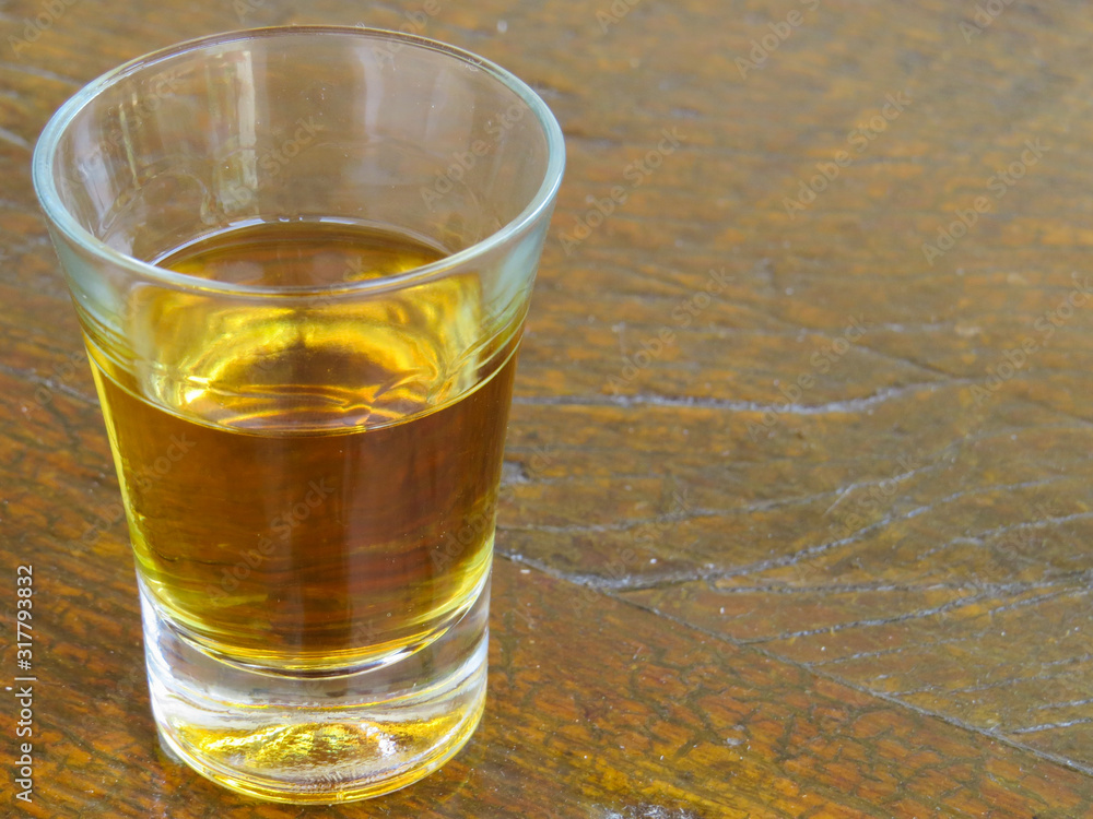 glass of cachaça on wooden table glass of cachaça on wooden table
