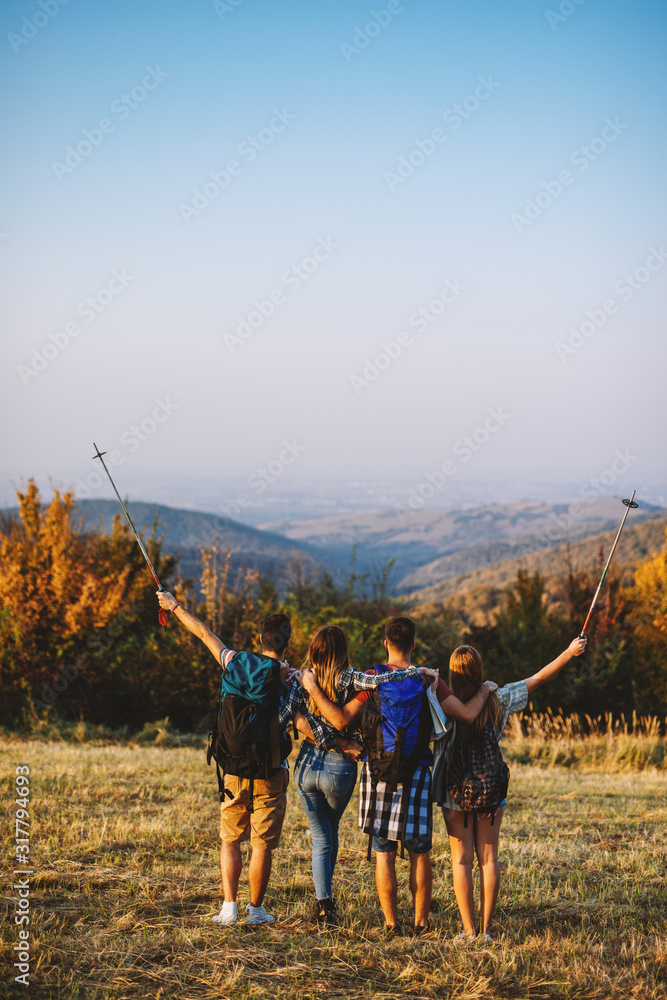 adventure, travel, tourism, hike and people concept - group of smiling friends walking with backpacks in nature - obrazy, fototapety, plakaty 