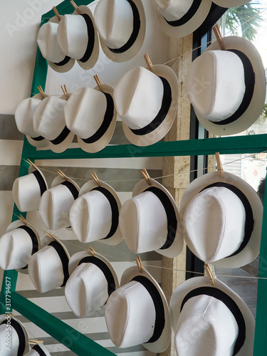 Hat rack display with rows of white straw woven hats