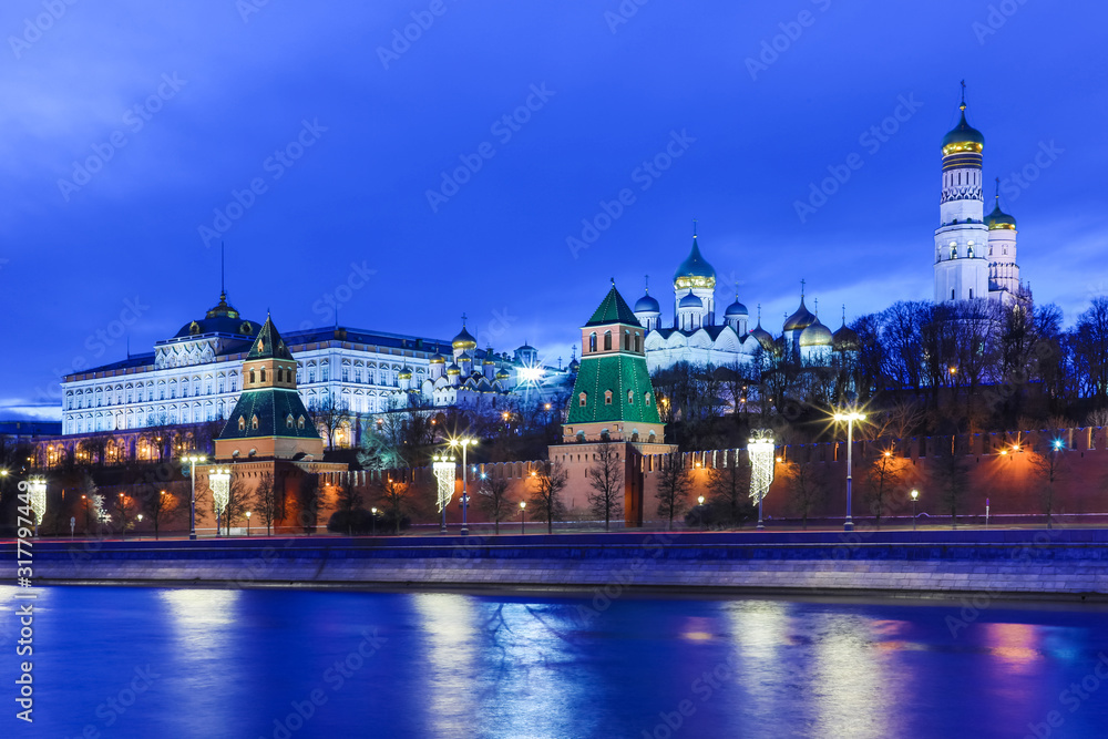 Illuminated Moscow Kremlin with Grand Kremlin Palace the government residence of president of Russia. View from the embankment of Moskva river. Evening urban landscape in the blue hour