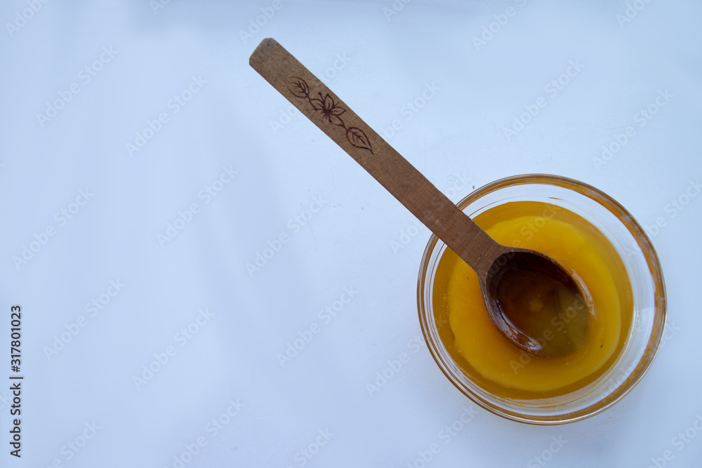 Yellow sweet honey on a white background. Flowing sweetness with a wooden spoon. Bee. Yellow sweet honey on a white background. Flowing sweetness with a wooden spoon. Bee.