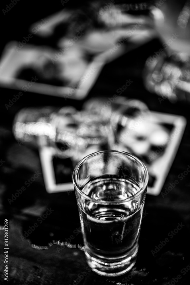 troubled family, social crisis. Photos and memories torn in a glass and spilled drink. Concept of alcoholism or separation, family conflict.