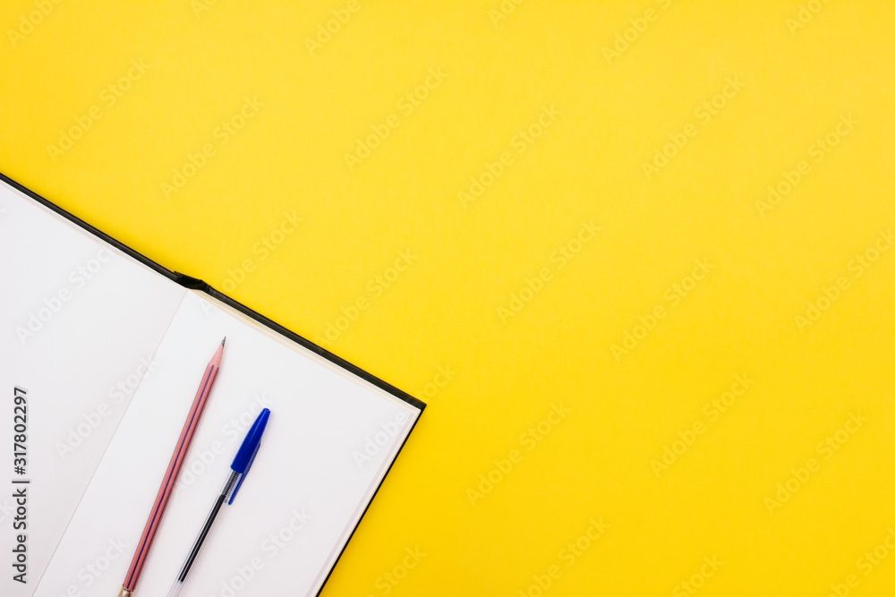 School and office supplies flay lay on colorful yellow background. Opened notebook, sketchbook, pen and pencil Top view with copy space. Back to school concept. Template, mockup for web. Stock photo. School and office supplies flay lay on colorful yellow background. Opened notebook, sketchbook, pen and pencil Top view with copy space. Back to school concept. Template, mockup for web. Stock photo.