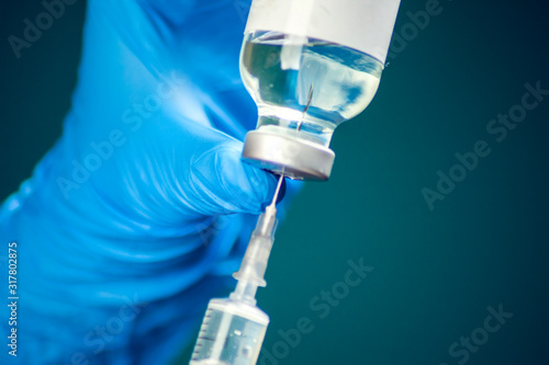 A doctor holding a bottle with vaccine and syringe. Medicine and healthcare concept