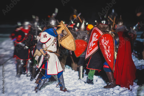 Medieval battle scene with cavalry and infantry, fight between crusaders and knights during historical reenactment
