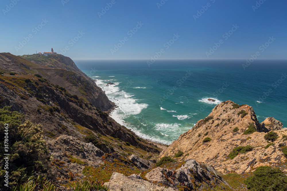 Scenic view of the rugged and dramatic coast at Cabo da Roca, the westernmost point of continental Europe, lighthouse and the Atlantic Ocean in Portugal.