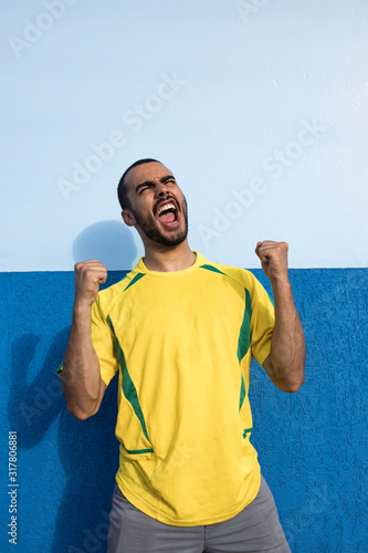 Young man sporting Brazilian football team. Cheering and Celebrating.