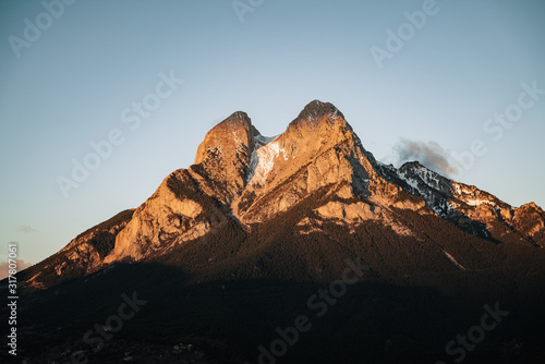 Snowcapped mountain peak against clear sky during sunrise