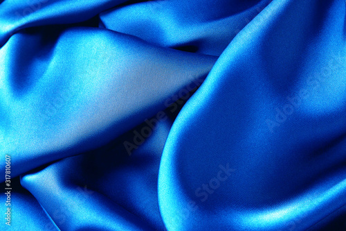 Blue sapphire color silk fabric background, top view.