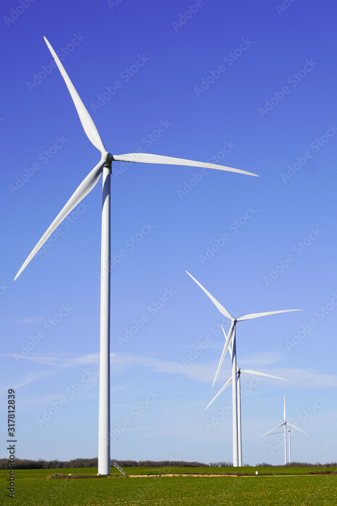 Flying windwheels wind power above big wind turbine on field in sunny day Flying windwheels wind power above big wind turbine on field in sunny day