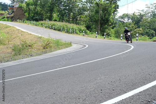 Man riding a classic motorcycle on highway of mountain