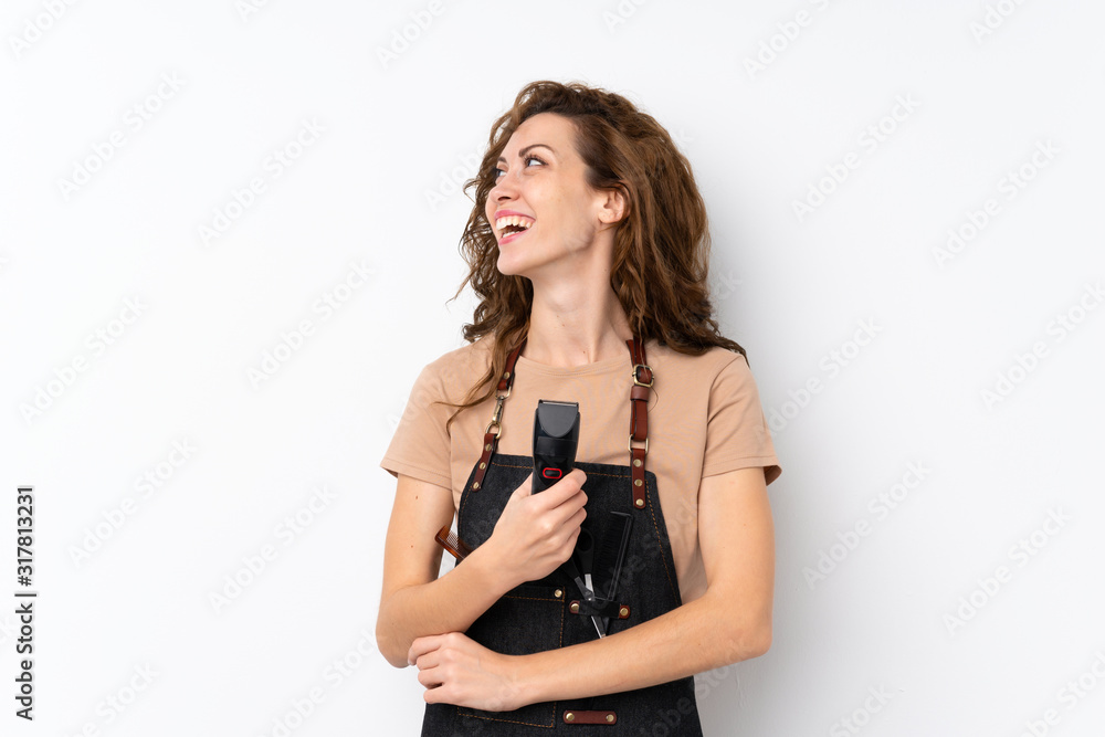 Young pretty woman over isolated background with hairdresser or barber dress and holding hair cutting machine Young pretty woman over isolated background with hairdresser or barber dress and holding hair cutting machine