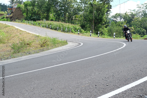 Man riding a classic motorcycle on highway of mountain