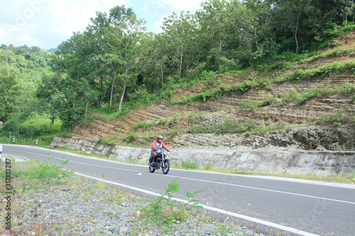 Man riding a classic motorcycle on highway of mountain
