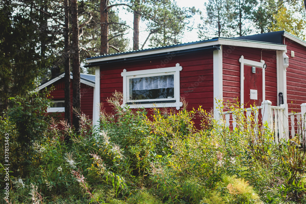 View of Classical swedish Camping site with traditional wooden red cabin cottage houses, Lapland, Northern Sweden