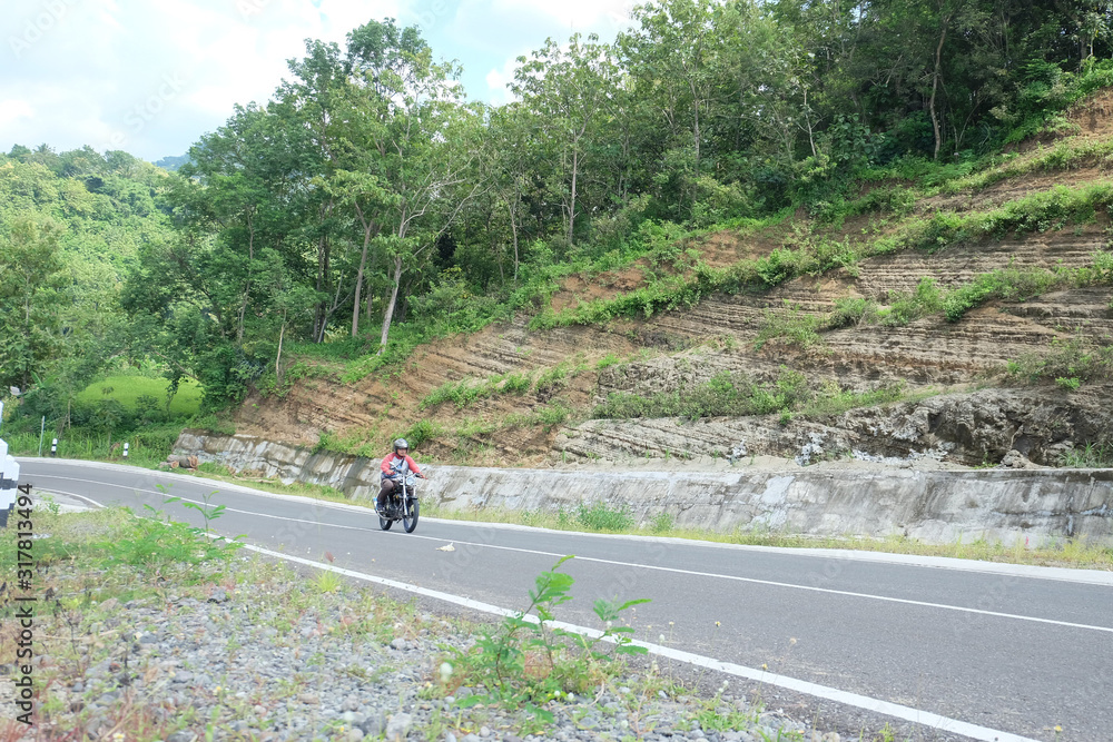 Man riding a classic motorcycle on highway of mountain