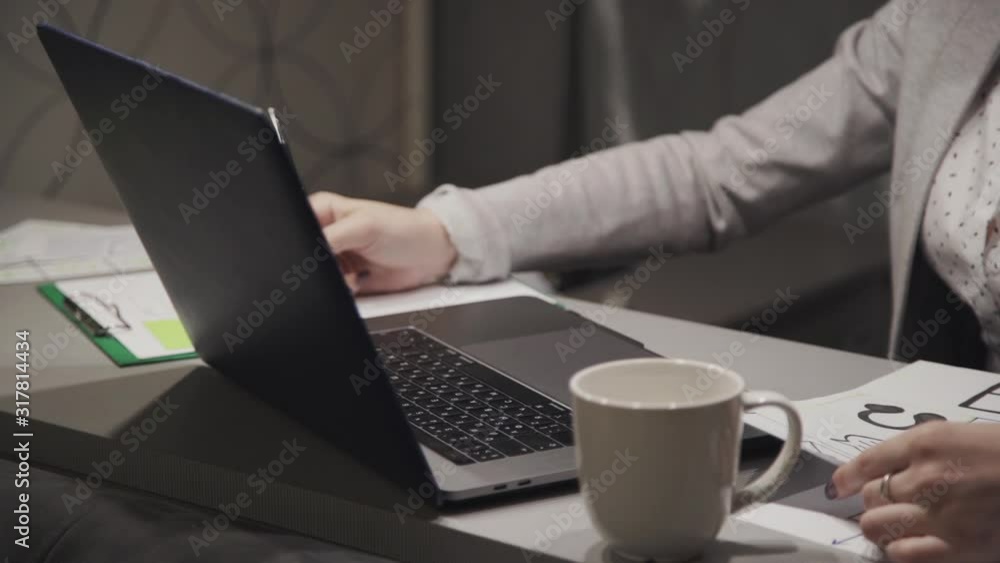Confident and successful freelancer sitting behind desk in work space at home. Young adult woman holding hands on keyboard using modern and personal computer, writing message online Confident and successful freelancer sitting behind desk in work space at home. Young adult woman holding hands on keyboard using modern and personal computer, writing message online