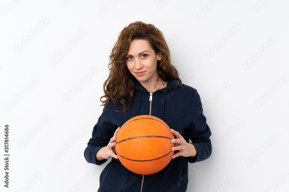 Young pretty woman over isolated background with ball of basketball