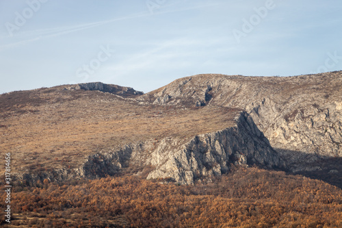 Rocky peaks and vivid autumn colors of the forest on Svrljig  Svrljiske  mountains in Serbia under a clear blue sky