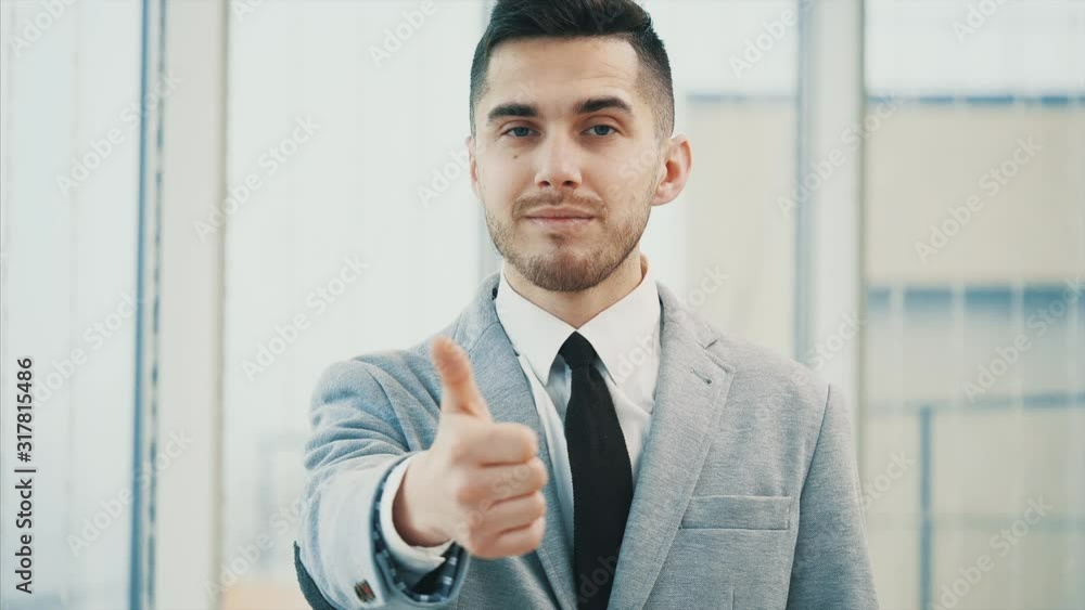 Business man is looking seriously for camera with his thumb finger up, isolated on white panoramic background. Close up. Copy space. 4K. Business man is looking seriously for camera with his thumb finger up, isolated on white panoramic background. Close up. Copy space. 4K.