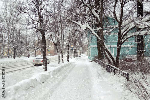 Streets and city road covered with snow during heavy snowfall in Europe. View of a street in the city covered with snowdrifts