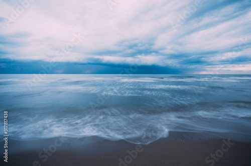 Storm approaching a beach during winter season, long exposure creating water motion,