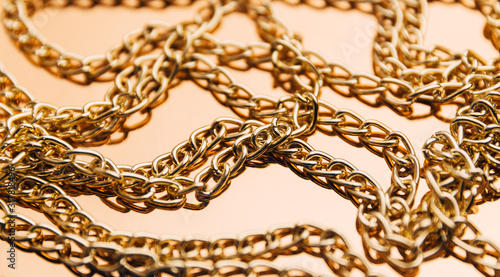 Shiny golden chains on reflective surface