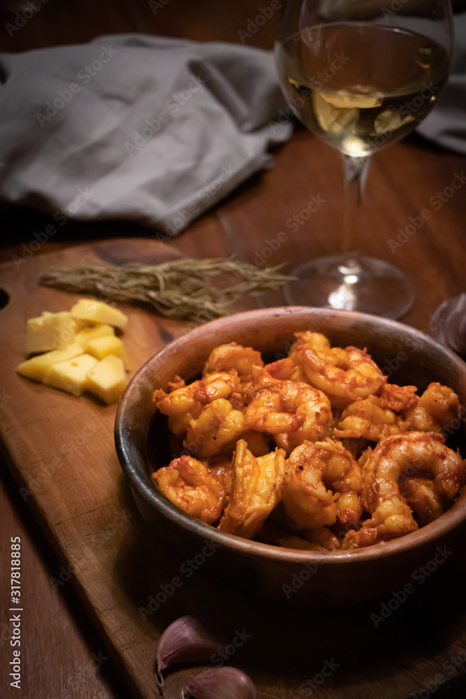 Argentinian garlic shrimp with glass of white wine on wooden table Argentinian garlic shrimp with glass of white wine on wooden table