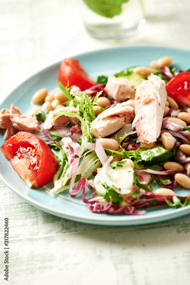 Healthy salad with tuna, cannellini bean, endive and tomatoes. Bright wwooden background. Healthy salad with tuna, cannellini bean, endive and tomatoes. Bright wwooden background.