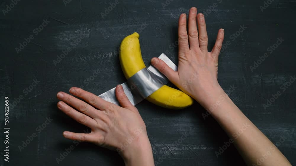 Art installation banana taped to a black wall 4k vídeo do Stock Adobe