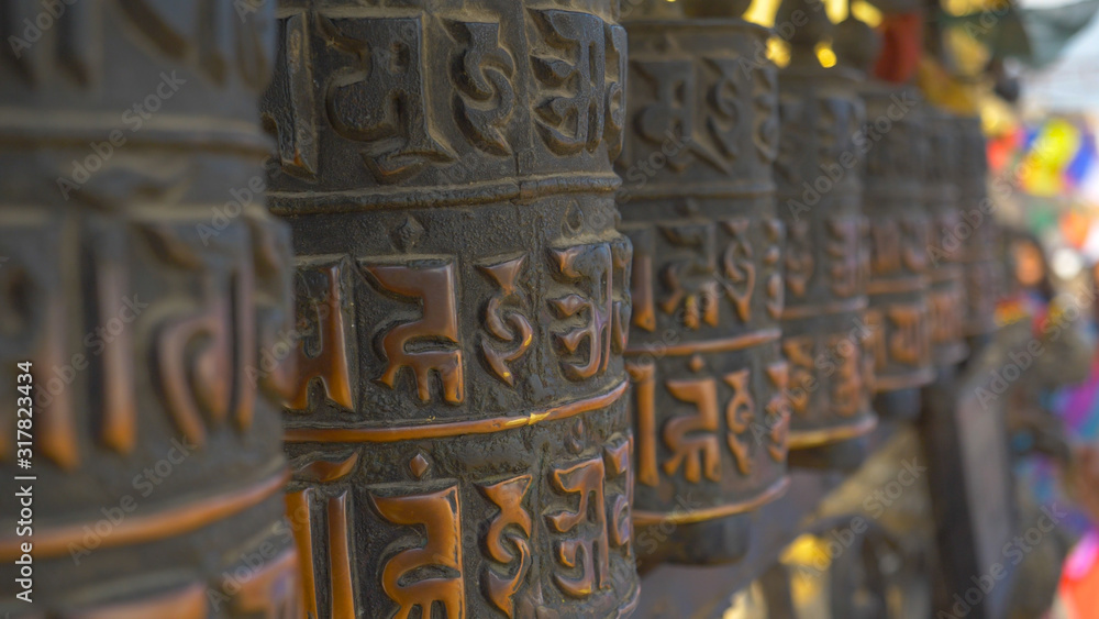 MACRO: Detailed view of ancient lettering written on the metal prayer wheels.